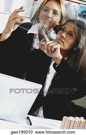 Two architects discussing a blueprint in an office and smiling View Large Photo Image Stock Image - Two architects discussing a blueprint in an office and smiling. Fotosearch