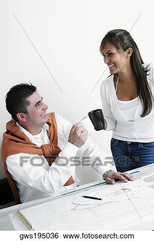 Two architects holding coffee cups in an office and smiling View Large Photo Image Stock Photograph - Two architects holding coffee cups in an office and smiling. Fotosearch