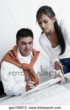 Two architects working on blueprints View Large Photo Image Stock Image - Two architects working on blueprints. Fotosearch