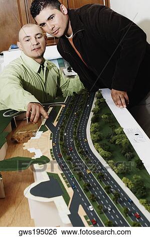 Two businessmen looking at an architectural model in an office and discussing View Large Photo Image Stock Photograph - Two businessmen looking at an architectural model in an office and discussing. Fotosearch