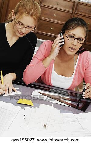 Two female architects drawing a blueprint in an office View Large Photo Image Stock Photo - Two female architects drawing a blueprint in an office. Fotosearch