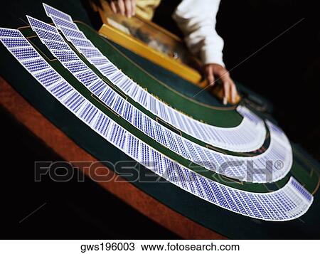 Casino worker dealing with playing cards on a gambling table View Large Photo Image Stock Image - Casino worker dealing with playing cards on a gambling table. Fotosearch