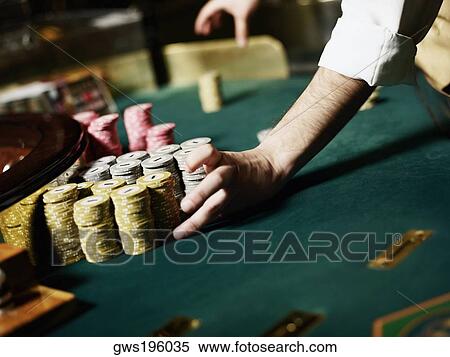 Casino worker's hand arranging gambling chips on a gambling table View Large Photo Image Stock Photography - Casino worker's hand arranging gambling chips on a gambling table. Fotosearch