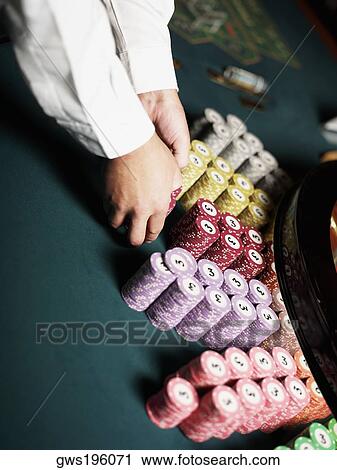 Close-up of a casino worker's hand arranging gambling chips on a gambling table View Large Photo Image Stock Image - Close-up of a casino worker's hand arranging gambling chips on a gambling table. Fotosearch