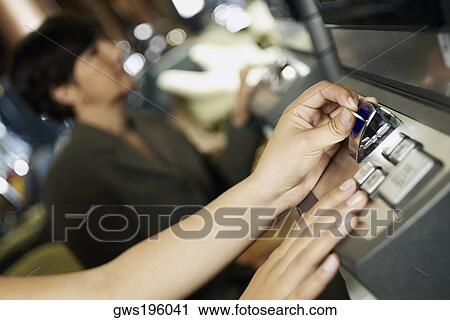 Stock Image - Close-up of a person playing slot machine at a casino. Fotosearch