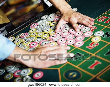 Close-up of a person's hand collecting gambling chips on a gambling table View Large Photo Image Picture - Close-up of a person's hand collecting gambling chips on a gambling table. Fotosearch