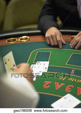 Close-up of a person's hand dealing with playing cards on a gambling table View Large Photo Image Stock Photograph - Close-up of a person's hand dealing with playing cards on a gambling table. Fotosearch