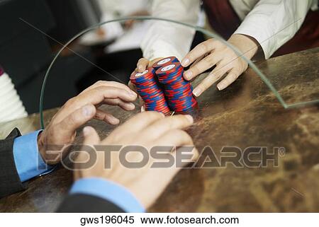 Close-up of a person's hand taking gambling chips from the checkout counter of a casino View Large Photo Image Stock Photography - Close-up of a person's hand taking gambling chips from the checkout counter of a casino. Fotosearch