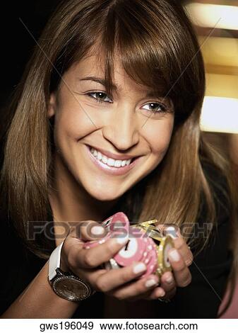 Stock Photo - Close-up of a young woman holding gambling chips. Fotosearch