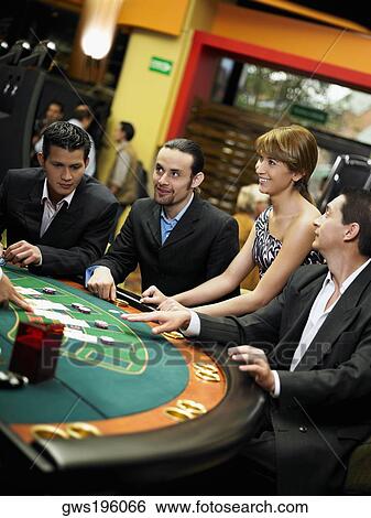 Stock Photograph - Four people playing blackjack in a casino. Fotosearch