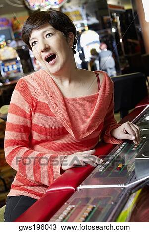 Mature woman playing on a slot machine and looking surprised View Large Photo Image Stock Image - Mature woman playing on a slot machine and looking surprised. Fotosearch