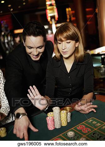 Mid adult man and a young woman gambling in a casino View Large Photo Image Stock Photography - Mid adult man and a young woman gambling in a casino. Fotosearch