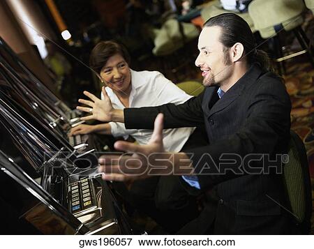 Mid adult man cheering in front of a slot machine with a mature woman smiling beside him View Large Photo Image Stock Photo - Mid adult man cheering in front of a slot machine with a mature woman smiling beside him. Fotosearch