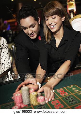 Mid adult man with a young woman placing gambling chips on a gambling table View Large Photo Image Stock Image - Mid adult man with a young woman placing gambling chips on a gambling table. Fotosearch