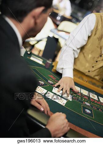 Mid section view of a casino worker dealing with playing cards on a gambling table View Large Photo Image Stock Image - Mid section view of a casino worker dealing with playing cards on a gambling table. Fotosearch