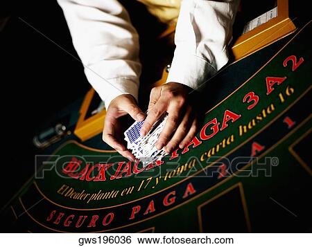 Mid section view of a casino worker's hand shuffling playing cards on a gambling table View Large Photo Image Stock Photograph - Mid section view of a casino worker's hand shuffling playing cards on a gambling table. Fotosearch