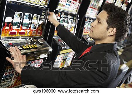 Side profile of a mid adult man playing on a slot machine View Large Photo Image Stock Image - Side profile of a mid adult man playing on a slot machine. Fotosearch