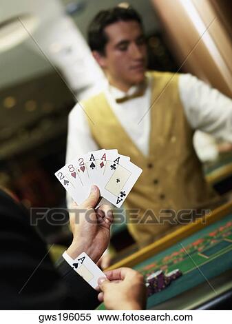 Young man holding playing cards and hiding an ace in his cuff View Large Photo Image Stock Photography - Young man holding playing cards and hiding an ace in his cuff. Fotosearch