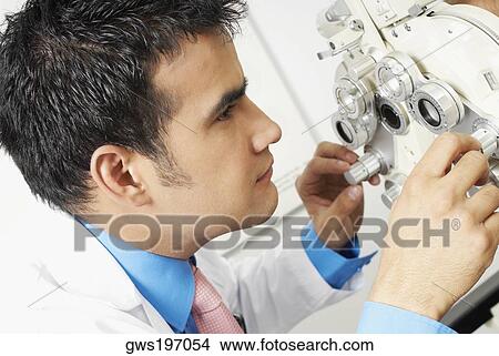 Close-up of a doctor looking through a phoropter View Large Photo Image Picture - Close-up of a doctor looking through a phoropter. Fotosearch