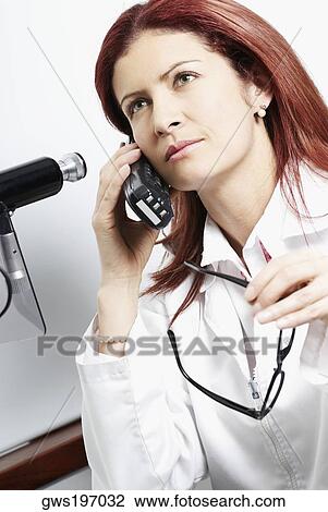 Close-up of a female doctor talking on a cordless phone View Large Photo Image Stock Image - Close-up of a female doctor talking on a cordless phone. Fotosearch