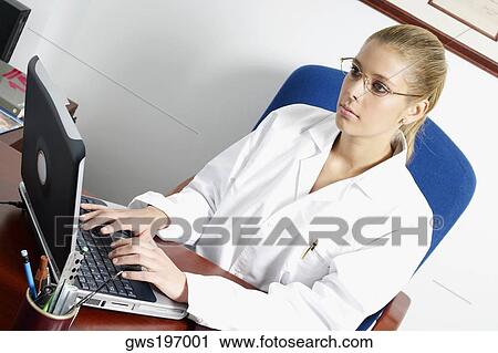 Stock Image - Close-up of a female doctor using a laptop. Fotosearch