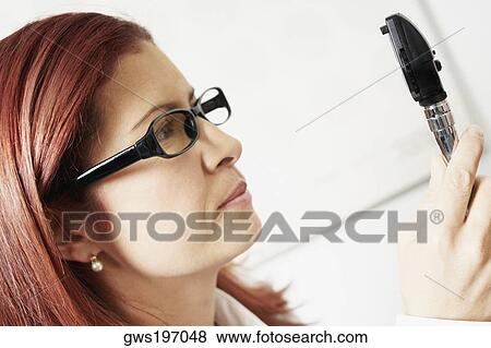 Close-up of a female optometrist holding an eye test equipment View Large Photo Image Stock Photo - Close-up of a female optometrist holding an eye test equipment. Fotosearch