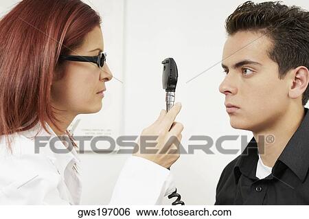 Close-up of a female optometrist examining eyes of a young man View Large Photo Image Stock Photograph - Close-up of a female optometrist examining eyes of a young man. Fotosearch