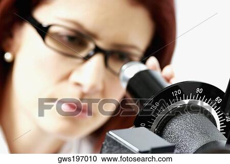 Stock Image - Close-up of a female optometrist using a phoropter. Fotosearch