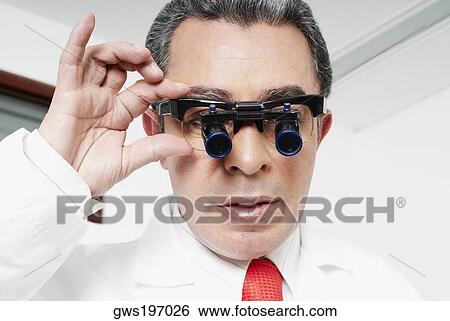 Close-up of a male doctor adjusting lupa binoculars View Large Photo Image Stock Photograph - Close-up of a male doctor adjusting lupa binoculars. Fotosearch