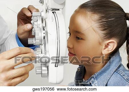 Stock Photograph - Doctor examining a girl's eye. Fotosearch