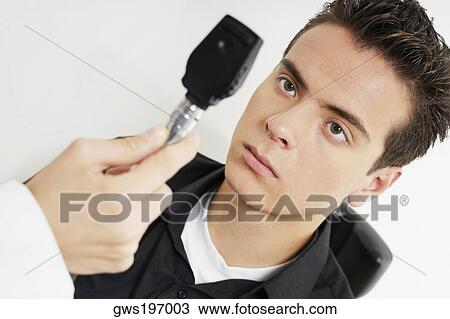 Doctor examining a young man's eye View Large Photo Image Stock Image - Doctor examining a young man's eye. Fotosearch