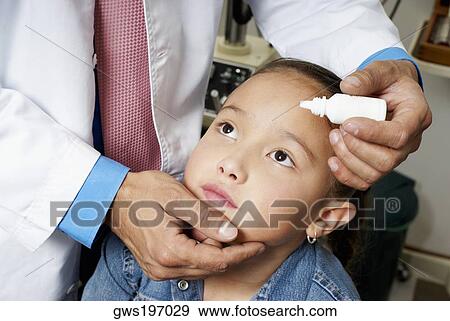 Mid section view of a doctor putting eye drops in a girl's eye View Large Photo Image Stock Photo - Mid section view of a doctor putting eye drops in a girl's eye. Fotosearch