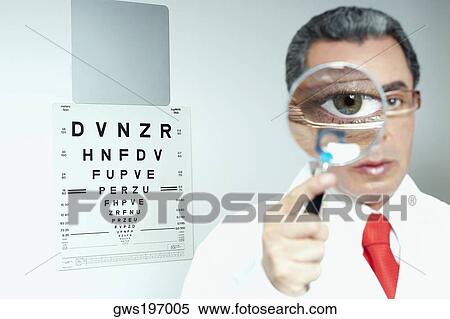 Portrait of a male doctor holding a magnifying glass in front of his eye View Large Photo Image Stock Photography - Portrait of a male doctor holding a magnifying glass in front of his eye. Fotosearch