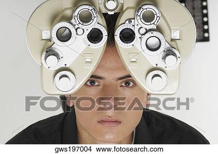 Portrait of a young man having sight test View Large Photo Image Picture - Portrait of a young man having sight test. Fotosearch