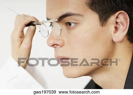 Stock Photo - Young man having sight test. Fotosearch