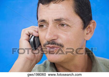 Stock Image - Close-up of a mature man talking on a mobile phone. Fotosearch