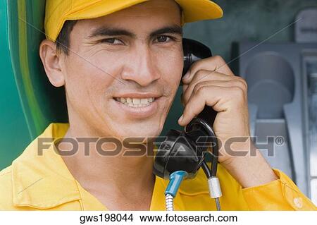 Picture - Portrait of a mid adult man talking on the telephone and smiling. Fotosearch