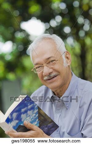 Portrait of a senior man holding a book and smiling View Large Photo Image Stock Photography - Portrait of a senior man holding a book and smiling. Fotosearch