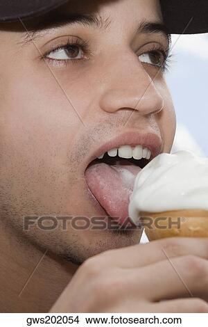 Close-up of a young man eating ice-cream View Large Photo Image Picture - Close-up of a young man eating ice-cream. Fotosearch