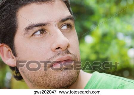 Stock Photo - Close-up of a young man looking away. Fotosearch