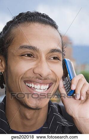 Close-up of a young man talking on a mobile phone View Large Photo Image Stock Photo - Close-up of a young man talking on a mobile phone. Fotosearch