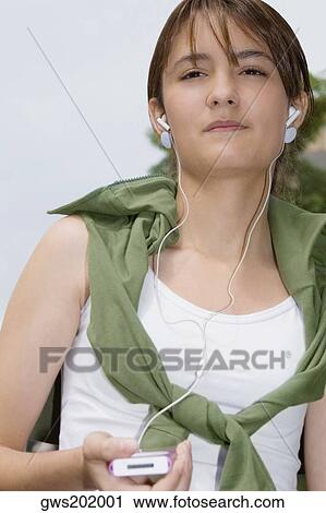 Close-up of a young woman listening to music View Large Photo Image Stock Image - Close-up of a young woman listening to music. Fotosearch