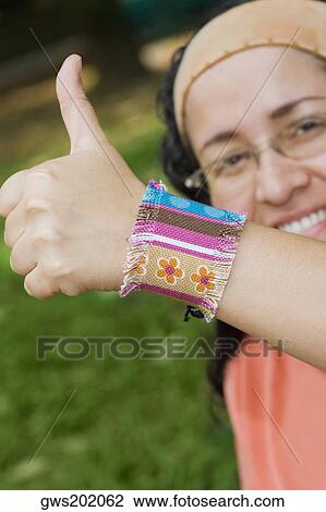 Portrait of a mid adult woman giving a thumbs up sign View Large Photo Image Stock Image - Portrait of a mid adult woman giving a thumbs up sign. Fotosearch