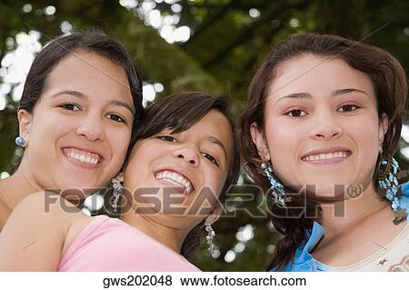 Portrait of a teenage girl smiling with two young women View Large Photo Image Stock Photo - Portrait of a teenage girl smiling with two young women. Fotosearch
