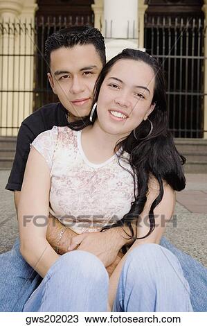 Portrait of a young man embracing a young woman from behind View Large Photo Image Stock Image - Portrait of a young man embracing a young woman from behind. Fotosearch