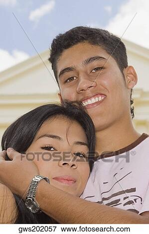 Portrait of a young man embracing a young woman and smiling View Large Photo Image Stock Photo - Portrait of a young man embracing a young woman and smiling. Fotosearch