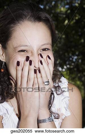 Portrait of a young woman covering her mouth with her hands View Large Photo Image Stock Photography - Portrait of a young woman covering her mouth with her hands. Fotosearch