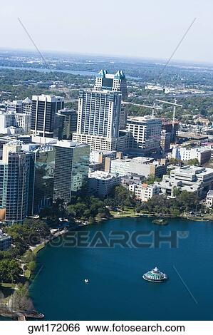 Stock Photograph - Aerial view of buildings along a lake, Lake Eola, Lake Eola Park, Orlando, Florida, USA. Fotosearch