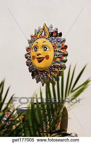Stock Photography - Close-up of a sun sculpture on a wall. Fotosearch