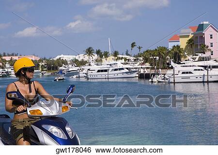 Mid adult woman driving a moped, Paradise Island, Bahamas View Large Photo Image Stock Photograph - Mid adult woman driving a moped, Paradise Island, Bahamas. Fotosearch